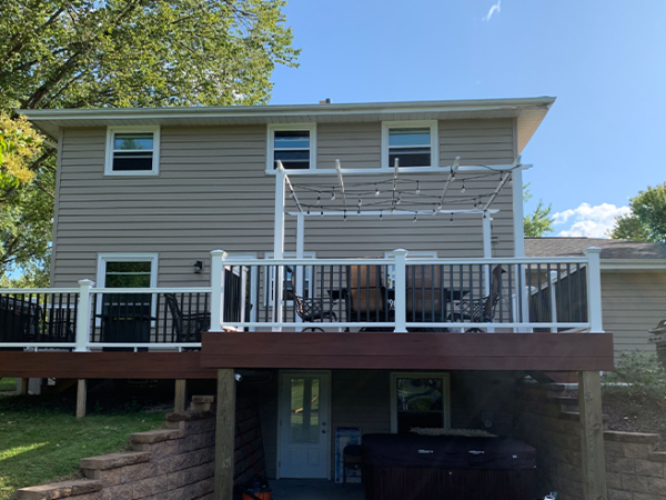 elevated-residential-deck-and-pergola-with-lighting-and-outdoor-dining-set-on-the-gray-house-in-west-bend-wi